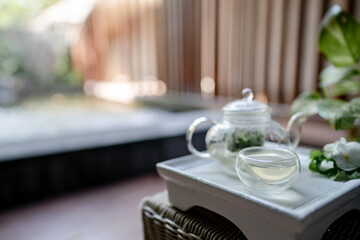 The tray of transparent teapot with herbal tea.