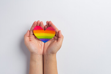 Womans hands hold rainbow heart awareness for LGBT community pride concept