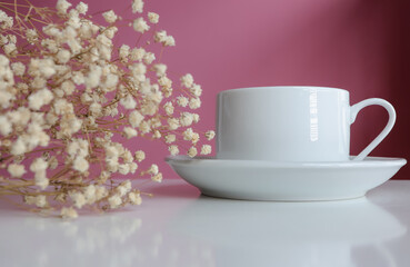 Coffee cup and white flowers on the table.