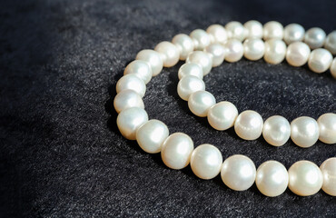 White pearls necklace on black flannel.