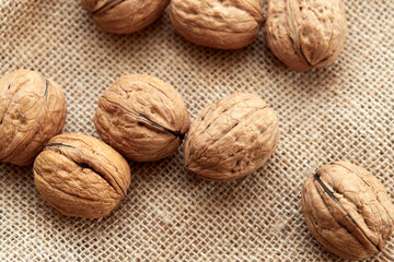Close-up walnuts lie on a burlap.