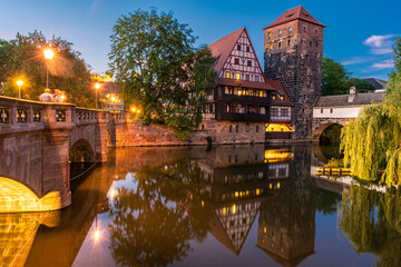 Fototapeta na wymiar NUREMBERG, GERMANY, 27 JULY 2020: A colourful and picturesque view of the half-timbered old houses on the banks of the Pegnitz river in Nuremberg at night
