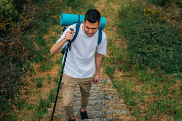 young hiker with hiking backpack practicing hiking or pilgrimage