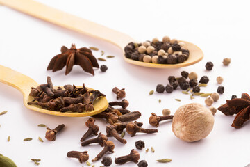 Fototapeta na wymiar Wooden spoon with cloves and black peppercorns side stock photo