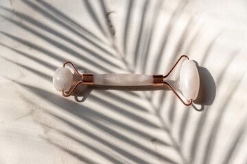 Rose quartz face roller for beauty facial massage therapy. Skin care tool for massaging morning...