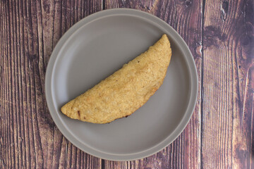 A quesadilla on a gray plate, ready to be prepared. Typical Mexican food