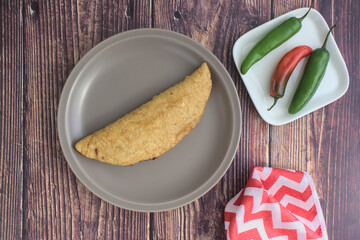 A quesadilla on a gray plate, ready to be prepared. Typical Mexican food