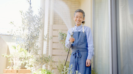 ベランダガーデニングするシニア男性　水やり