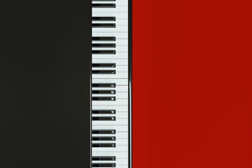 Top view of piano keyboard on red background