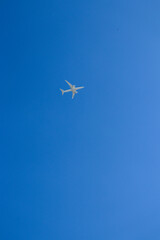 Airplane high in blue sky. Bright blue sky with a flight.