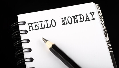 HELLO MONDAY written text in small notebook on a black background