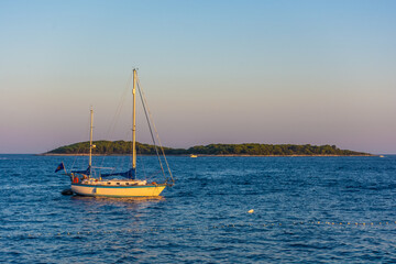 Fototapeta premium View of a boat sailing toward the Pakleni Islands from Hvar at sunset, Croatia