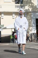 man in bathrobe crossing the street