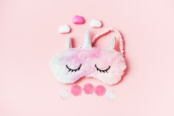  sleeping eye mask furry fur unicorn on pink paper background. Top view, flat lay. Concept relaxation and sweet dreams