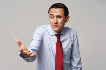 business men in shirt and tie showing hand to the side on gray background cropped view