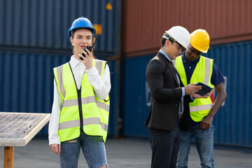 woman factory worker or engineer using walkie talkie for preparing a job in containers warehouse storage