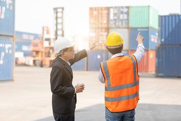 back view shot businessman talking with man engineer in containers warehouse storage