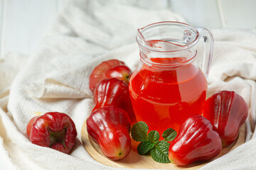 Rose apple juice on white wooden backgroud