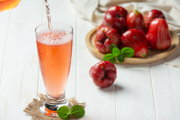 Rose apple juice on white wooden backgroud