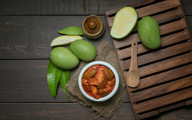 organic homemade mango pickle or aam ka achar or achaar in a white bowl and traditional theme 