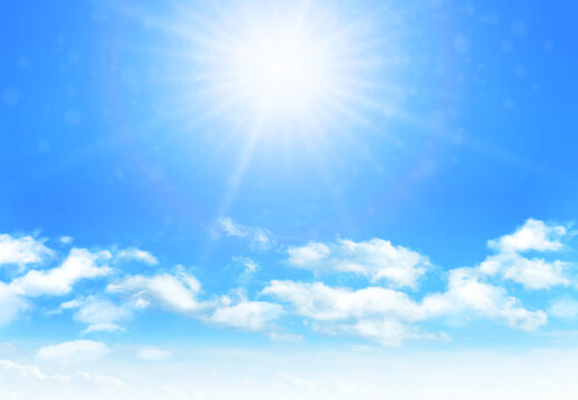 Sunny day background, blue sky with white cumulus clouds and glaring sun