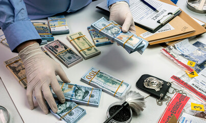 Specialised police officer notes dollar banknote reference of a robbery in criminal investigation unit, conceptual image