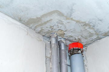 Sewer and water pipes installed in an apartment under construction. Bottom up view. Selective focus