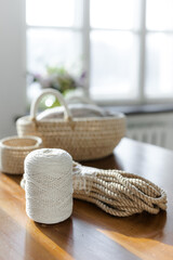 Fototapeta na wymiar Handmade home decor made from organic jute fiber. Two wicker jute baskets are placed on a wooden table. jute rope and fiber. the concept of home decor and comfort in the eco style.