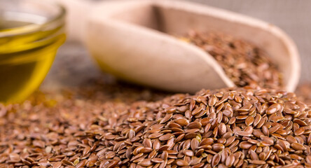 Brown flax seeds and flaxseed oil on a wooden table