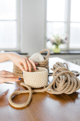 Handmade home decor made from organic jute fiber. Two wicker jute baskets are placed on a wooden table. jute rope and fiber. the concept of home decor and comfort in the eco style.