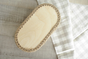 Handmade home decor made from organic jute fiber and wood. wooden oval bottom of a jute basket on the table.