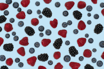 Berries pattern isolated on light blue. Strawberries, raspberries blackberries and blueberries arranged on light blue.