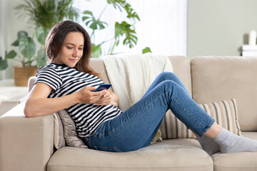Young woman using phone at home