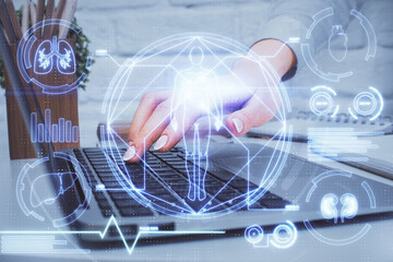 Double exposure of woman hands typing on computer and general theme hologram drawing. Education concept.