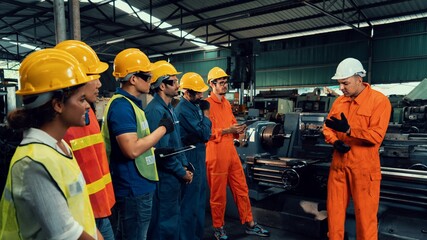 Skillful worker attending brief meeting in the factory . Industrial people and manufacturing labor...