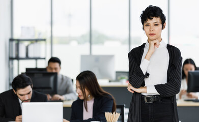 Fototapeta premium Cute and beautiful businesswoman in suit dress standing in the office and touc her chin with self-confident and elegant pose