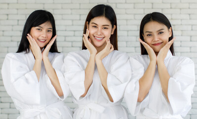 Portrait 3 asian adults women with long black hair wearing apa style white robes Smiling and looking at the camera her hands touched on her face looked happy with her skin face. Shoot in a studio room - obrazy, fototapety, plakaty