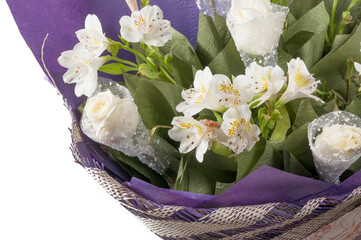 Bouquet of flowers in a purple wrapper close-up..White roses and white alstroemeria in a luxurious bouquet.