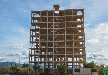 Structure of an abandoned building under construction, in a sunset with blue sky and a little cloudy.