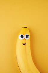 Funny smiling banana with eyes concept isolated on yellow background with copy space © amixstudio