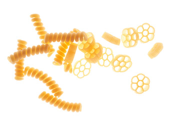 Mix of different varieties of pasta on white background, bottom lighting, assorted macaroni.