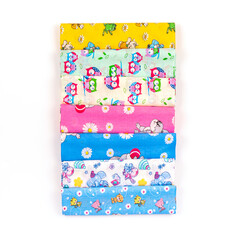 Baby fabric colorful diapers for newborns, top view. Cotton fabric stacked in layers on a white background. Natural fabric for sewing clothes and bed linen. Chintz with bright children's colors.