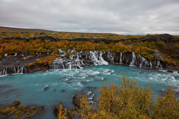 Fototapeta na wymiar Unusual blue waterfall in Iceland Hraunfossar