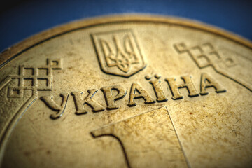 Translation of the inscription: Ukraine. Fragment of the Ukrainian coin in 1 hryvnia. Aged showy illustration on the theme of economy and public finance. Vignetting. Focus on the name of the country