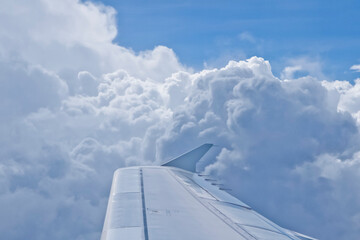 Fototapeta na wymiar Wing of airplane flying through clouds