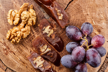 Churchkhela, national Georgian dessert made from grape juice and walnuts, composition on a wooden table