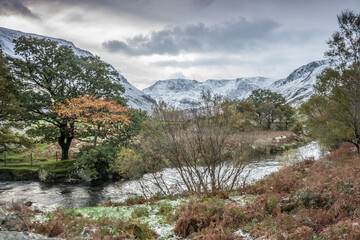 Fototapeta na wymiar dramatic photo of the wintry autumn weather and snow capped mountains in the Nant Ffrancon Pass and Ogwen valley in Snowdonia National Park in North Wales.