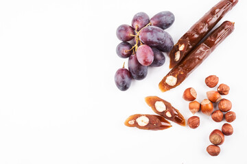 Churchkhela, national Georgian dessert made from grape juice and hazelnuts, isolated composition on white background, copy space