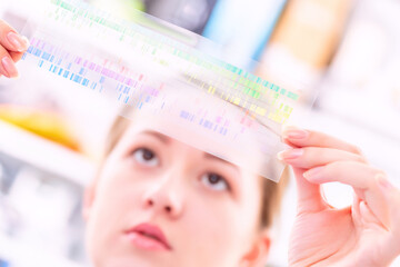 Young woman examines a spectroscopy picture in a quantum physics laboratory