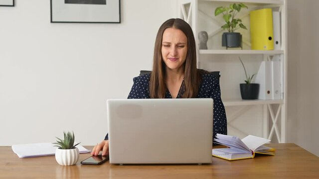 Irritated female office employee closing laptop with stressed facial expression, woman has problem with project, unexpected computer crash or error, data loss